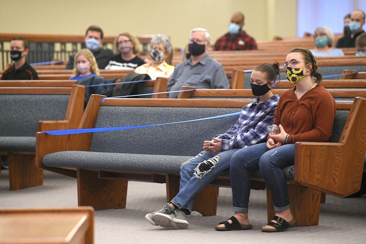 Grace Sexton, 14, and Grace Ayer, 15, sit in the front row and wait to participate in the Good Friday service at Spokane Valley Church of the Nazarene Friday, April 2, 2021. Though church attendance is more relaxed than last Easter, most churches are still practicing social distancing, masking and livestreaming services to those who can