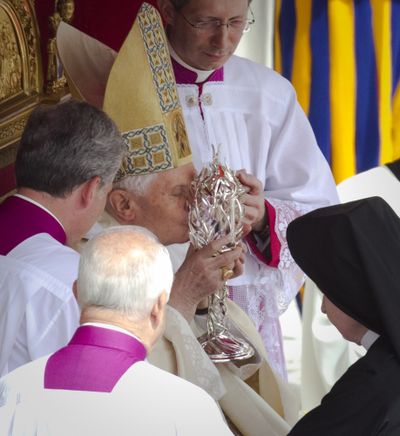Pope Benedict XVI kisses the glass reliquary containing the blood of the late Pope John Paul II on Sunday. (Associated Press)