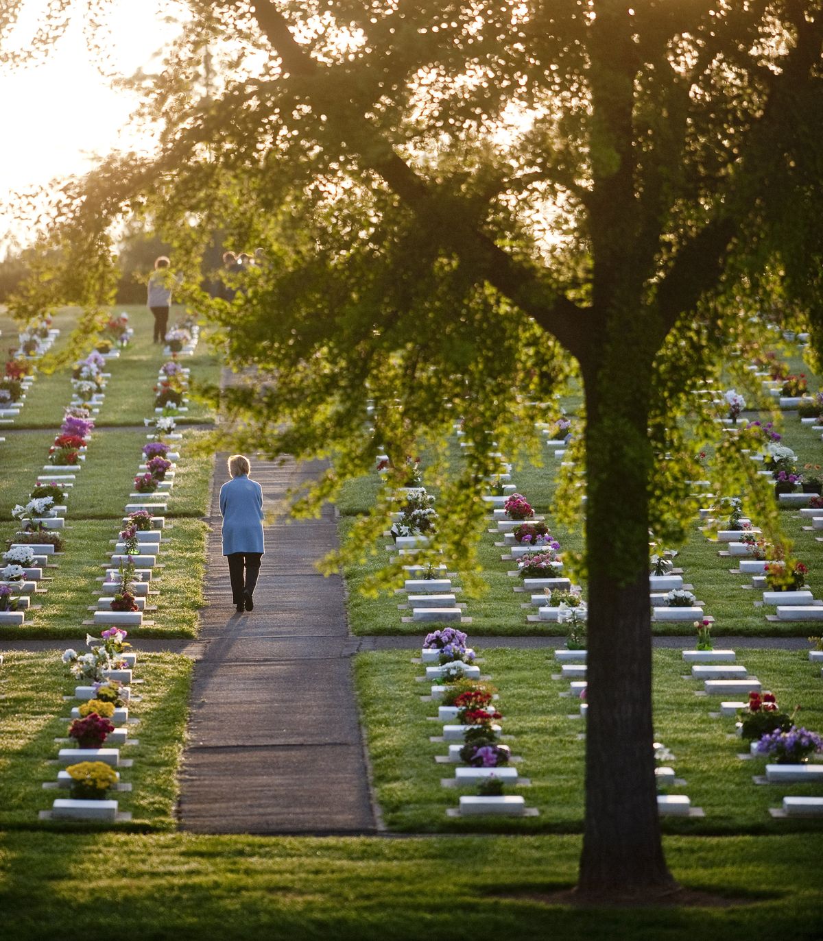 A woman walks through rows of headstones in God’s Acre cemetery in Winston- Salem, N.C., after the Easter sunrise service Sunday. As part of Easter week traditions, Moravian church members clean the uniform gravestones. (Associated Press)