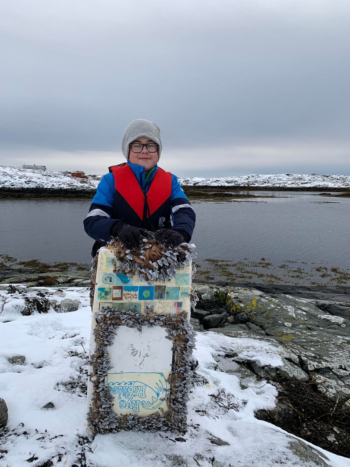Karel Nuncic, a sixth-grade student who lives in Dyrnes, Norway, poses on Feb. 1 with the Rye Riptides boat he and his parents found on the island of Smøla. 
