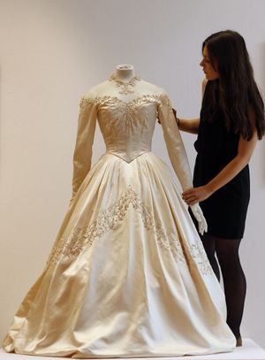 A Christie's employee adjusts Elizabeth Taylor's first wedding dress, designed by the legendary costume designer Helen Rose, at the auction house Christie's in London, Wednesday, June 19, 2013. The wedding dress is part of the auction 120 years of Pop Culture, which is showcasing important memorabilia dating from every decade of the past century of popular culture from the ubiquitous industries of film and music. The estimated price is 30,000 � 50,000 pound (46,000-78,000 dollars). (Frank Augstein / Associated Press)