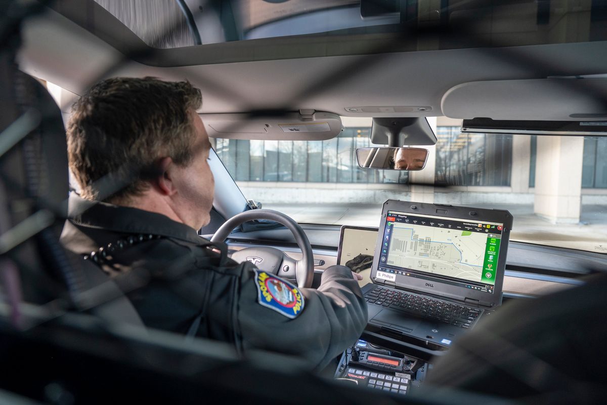 Spokane Police Officer Shane Phillips on Thursday shows how an officer’s laptop, used to receive calls and display information about people and automobiles, actually hides the permanently mounted car controls on a touch screen in the police version of the Tesla sedan currently being tested by the police department in Spokane.  (Jesse Tinsley/The Spokesman-Review)