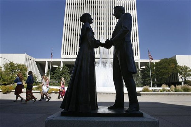 In this Saturday, Oct. 6, 2012 file photo, women walk by a statue of Joseph and Emma Smith outside the church office building during the 182nd Semiannual General Conference for The Church of Jesus Christ of Latter-day Saints in Salt Lake City. The Church of Jesus Christ of Latter-day Saints has entered a new era after Mitt Romney's run for president in 2012. His candidacy illuminated a changing landscape for the religion, where Americans are growing more curious than fearful about the faith, and allies can be found even among Christians with deep misgivings about Mormon beliefs.  (AP/Salt Lake Tribune / Scott Sommerdorf)