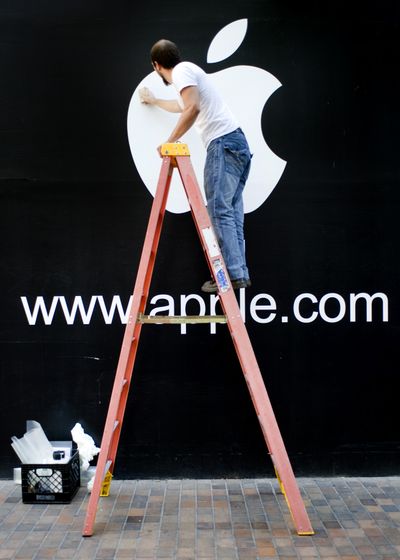 Adam Norwood of SignSouth installs a temporary Apple logo on the exterior of the former Eddie Bauer store  at River Park Square on Aug. 19. It was the first public acknowledgment by the company that an Apple Store will open soon in Spokane.  (Colin Mulvany)