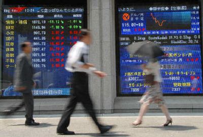 
Pedestrians walk past an electric stock board in Tokyo. A new survey ranks the Japanese capital tops in the world in terms of purchasing power. 
 (Associated Press / The Spokesman-Review)