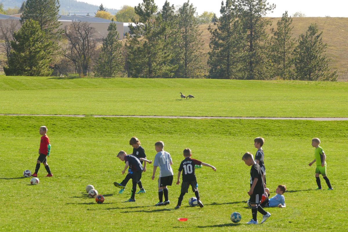 Kids involved in the Washington East Soccer Club warm up for practice Monday, April 29, 2019 at Plantes Ferry Park. Proposed enhancements for the large Spokane County park include putting artificial turf on two soccer fields and a softball field to make the fields playable more days of the year. (Jesse Tinsley / The Spokesman-Review)