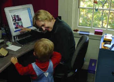 
Deborah Lear shows her grandson, Lazarus, his pictures on the Internet at her home in Philadelphia. Lear keeps track of her grandchildren via a baby blog documenting what is happening in their lives in New Mexico. 
 (Knight Ridder / The Spokesman-Review)