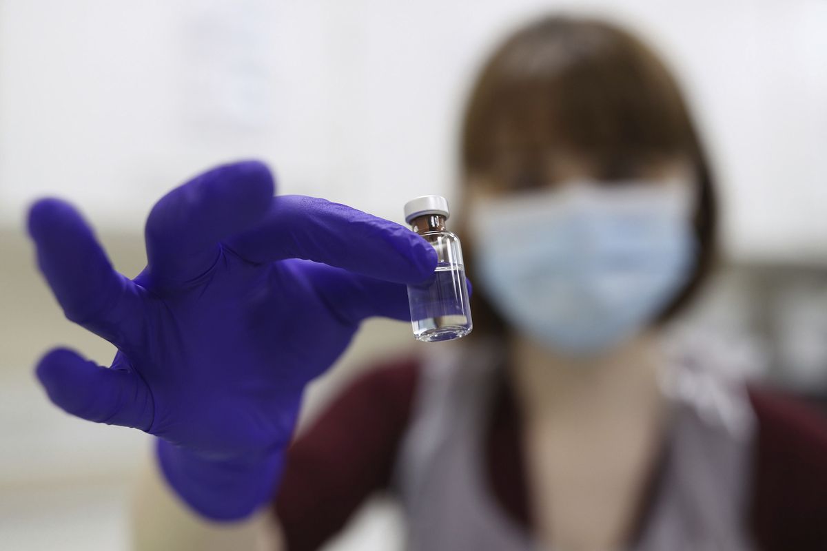 A National Health Service pharmacy technician at the Royal Free Hospital simulates the preparation of the Pfizer vaccine to support staff training ahead of the rollout in London on Friday.  (Yui Mok)