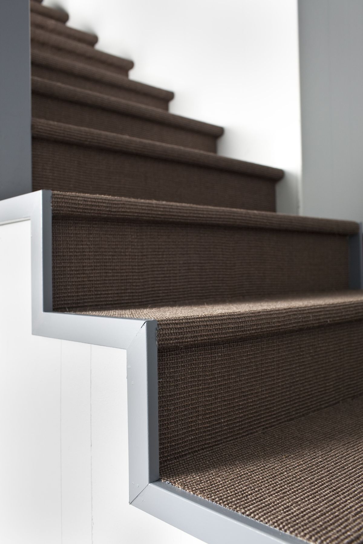 Brian Patrick Flynn’s design of a basement staircase includes organic elements such as sisal for a warm, welcoming feeling.