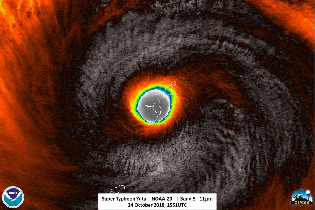 This false-color satellite image provided by the National Oceanic and Atmospheric Administration (NOAA) shows the moment the eye of Super Typhoon Yutu passed over Tinian, one of three main islands in the U.S. Commonwealth of the Northern Mariana Islands, producing damaging winds and high surf Wednesday, Oct. 24, 2018. The National Weather Service in Honolulu says maximum sustained winds of 180 mph  were recorded around the eye of the storm, which passed over Tinian island and Saipan early Thursday morning local time. Waves of 25 to 40 feet are expected around the eye of the storm. (NOAA / Associated Press)