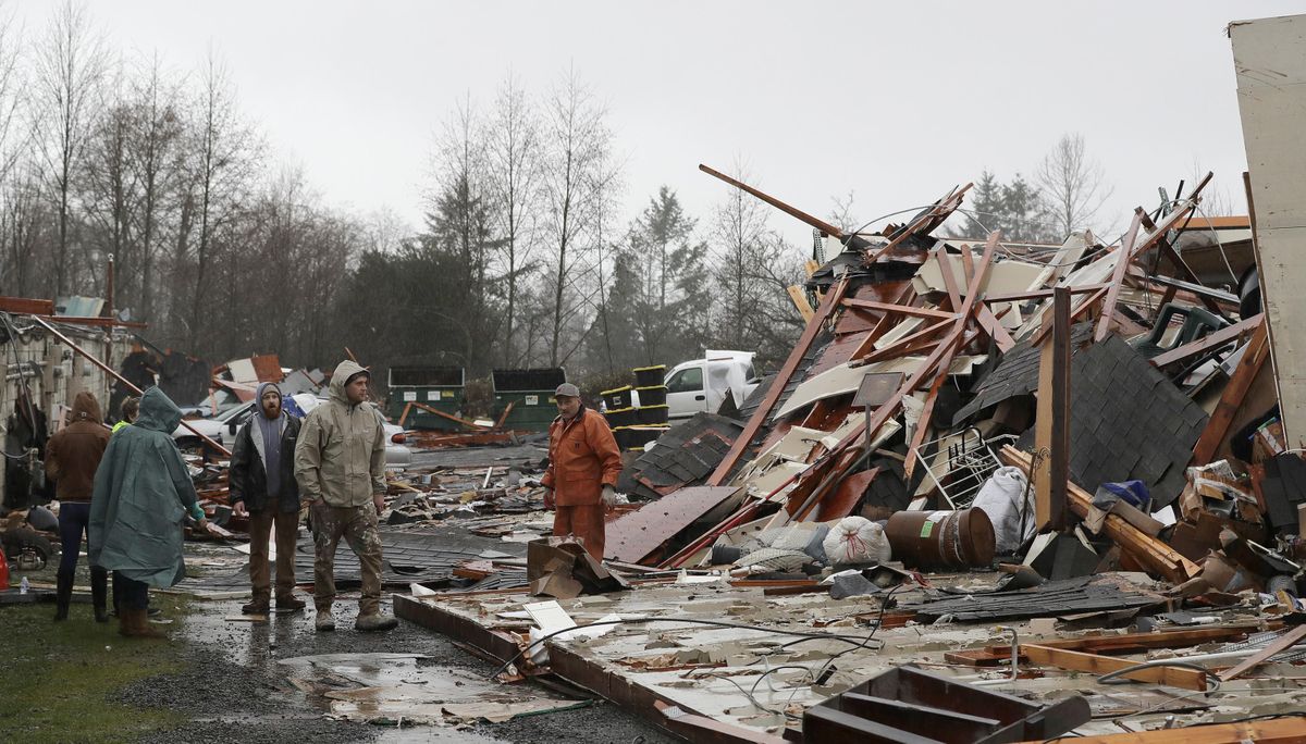 People walk through debris at Salmonberry Dry Storage, on Wednesday, Dec. 19, 2018, in Port Orchard, Wash., where a tornado touched down Tuesday. A National Weather Service storm damage survey team was working elsewhere in the neighborhood to assess the damage. (Ted S. Warren / AP)