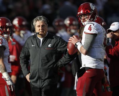 Washington State head coach Mike Leach, left, confers with quarterback Luke Falk during an injury time out against Colorado in the first half of an NCAA college football game, Saturday, Nov. 19, 2016, in Boulder, Colo. (David Zalubowski / AP)