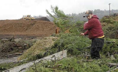 
Rob Beerbower unloads a trailer full of tree branches at a dumpsite at Grays Harbor Paper LP in Hoquiam, Wash. The branches, blown down during the recent storm that hit Grays Harbor County, will be ground up and burned in the company's boiler, producing  energy to make paper at the mill. Associated Press
 (Associated Press / The Spokesman-Review)