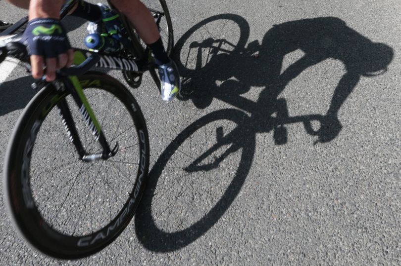 A cyclist casts a shadow on the tarmac prior to the start of the eleventh stage of the Tour de France cycling race over 116.8 miles with start in Pau and finish in Cauterets, France, Wednesday, July 15, 2015.  (AP Photo/Christophe Ena)