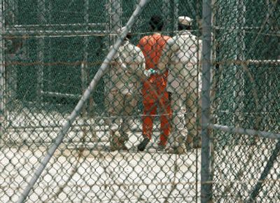 
 An unidentified detainee is escorted by two military guards at Camp Delta, at Guantanamo Bay Naval Base, Cuba, in June 2005. 
 (Associated Press / The Spokesman-Review)