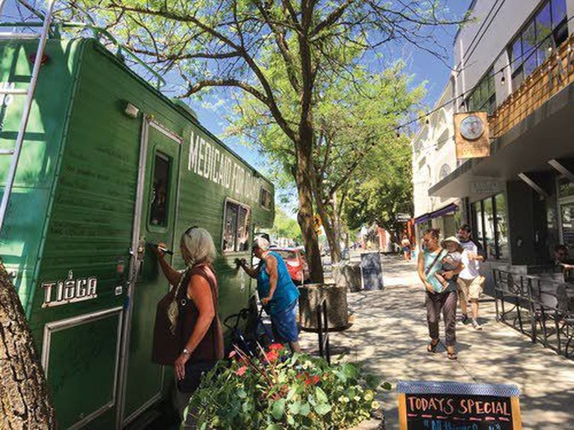 Medicaid expansion supporters sign the Medicaid mobile during a stop in Moscow last summer. (Garrett Strizich)