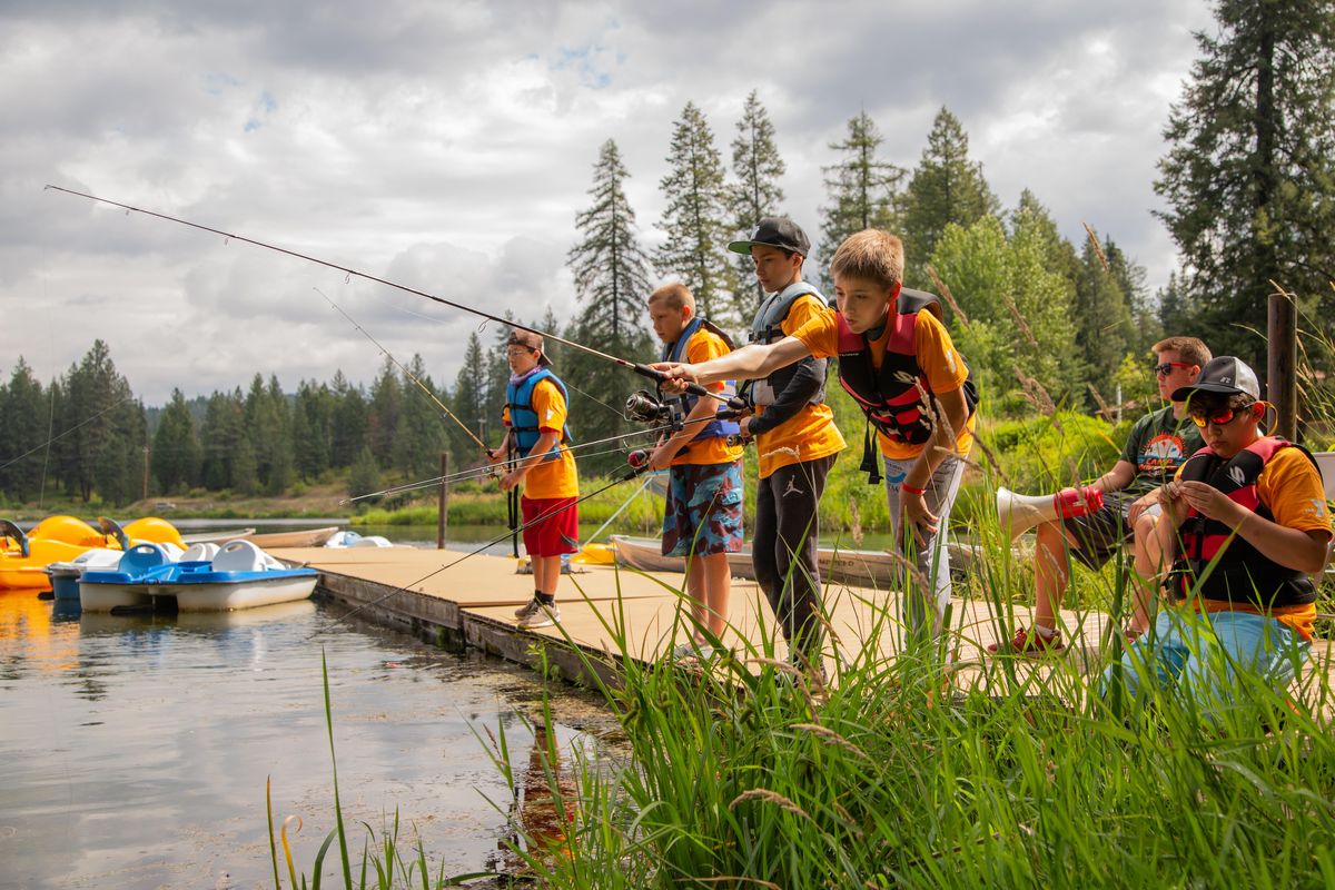 Campers go fishing on a dock at YMCA Camp Reed on Fan Lake during Camp Goodtimes on July 10, 2018. Camp Goodtimes is hosted for children affected by childhood cancer and their friends. (Libby Kamrowski / The Spokesman-Review)