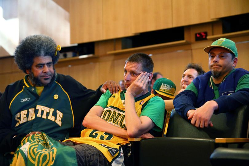Seattle SuperSonics fans Kris “Sonics Guy” Brannon, left, Kenneth Knutsen, center, and Jason Billingsley react to the Seattle City Council’s  no vote against a “street vacation” vacating stretch of road where investor Chris Hansen hopes to eventually build an arena that could house an NBA and NHL team. (Genna Martin / Associated Press)