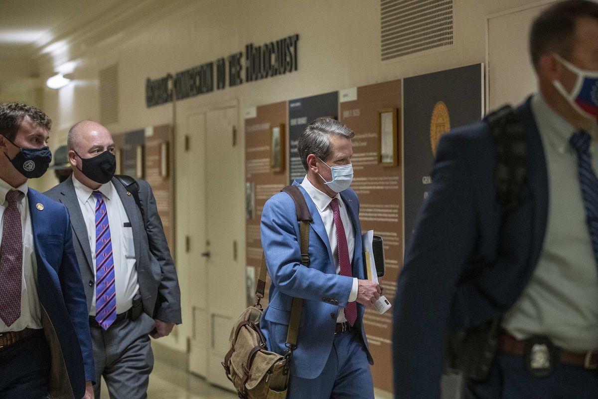 Georgia Gov. Brian Kemp, second from right, leaves the Georgia State Capitol Building after he signed into law a sweeping Republican-sponsored overhaul of state elections that includes new restrictions on voting by mail and greater legislative control over how elections are run, Thursday, March 25, 2021 in Atlanta.  (Alyssa Pointer)