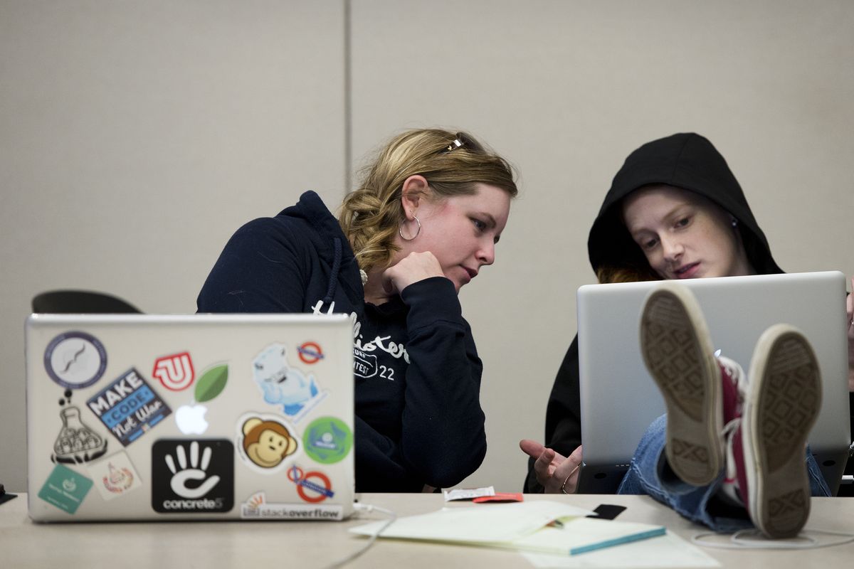 Alexa Lohmeyer, left, views the graphics changes Rebecca Meredith made to their Spo-Relics website on Saturday during SpoCode at the Spokane Fire Training Center. Spo-Relics lists regional historic buildings. (Dan Pelle)