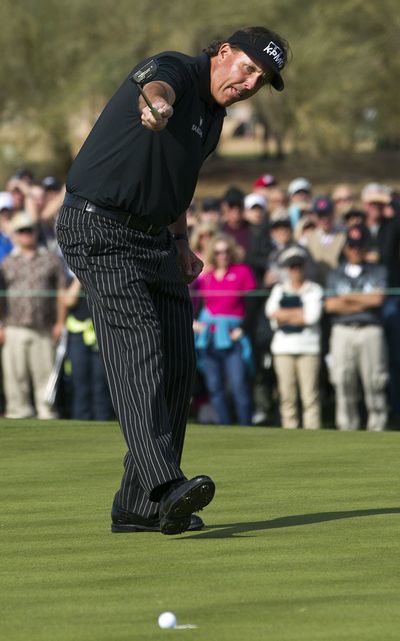 Phil Mickelson watches his birdie putt roll towards the cup. (Associated Press)