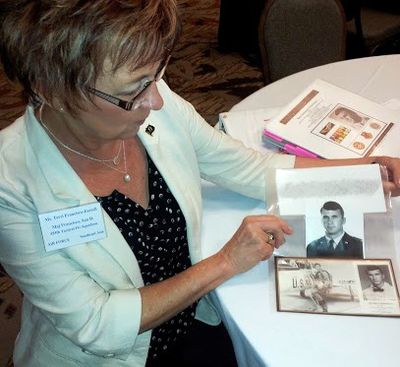 Terri Francisco-Farrell, of Kennewick, looks at photos of her brother, Maj. San D. Francisco, who was shot down over North Vietnam in November 1968 and declared missing in action. (Kevin Graman / The Spokesman-Review)