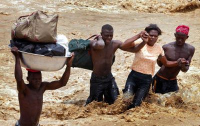 
Haitians cross a river after a bridge collapsed during Hurricane Dennis in Grand Goaves, Haiti, southwest of Port-au-Prince on Friday
 (AP / The Spokesman-Review)