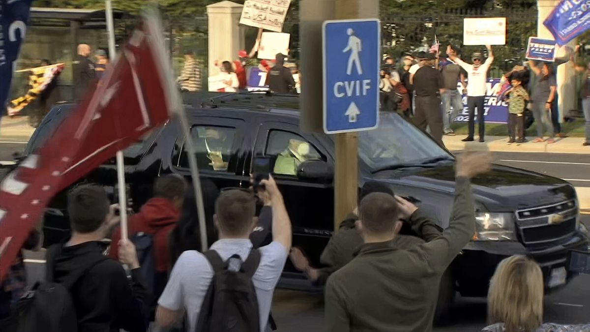 In this image from video, President Donald Trump waves as he drives past supporters gathered outside Walter Reed National Military Medical Center in Bethesda, Md., Sunday, Oct. 4, 2020. Trump was admitted to the hospital after contracting COVID-19.  (Carlos Vargas)