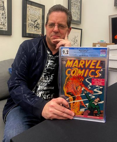 Stephen Fishler, co-owner and CEO of ComicConnect.com, sits for a photo holding up a copy of Marvel Comics #1 on Friday in New York. The prized copy of the first-ever Marvel comic book has fetched more than $2.4 million in an online auction.  (Michael Cohen)