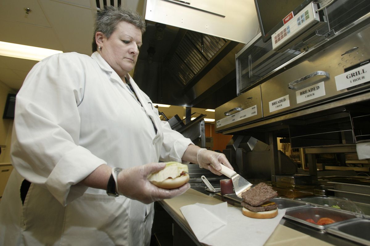 Liz Shires, Wendy’s research and development laboratory coordinator, assembles one of the new Dave’s Hot ’N Juicy Cheeseburgers in the lab at the company’s international headquarters in Dublin, Ohio. (Associated Press)