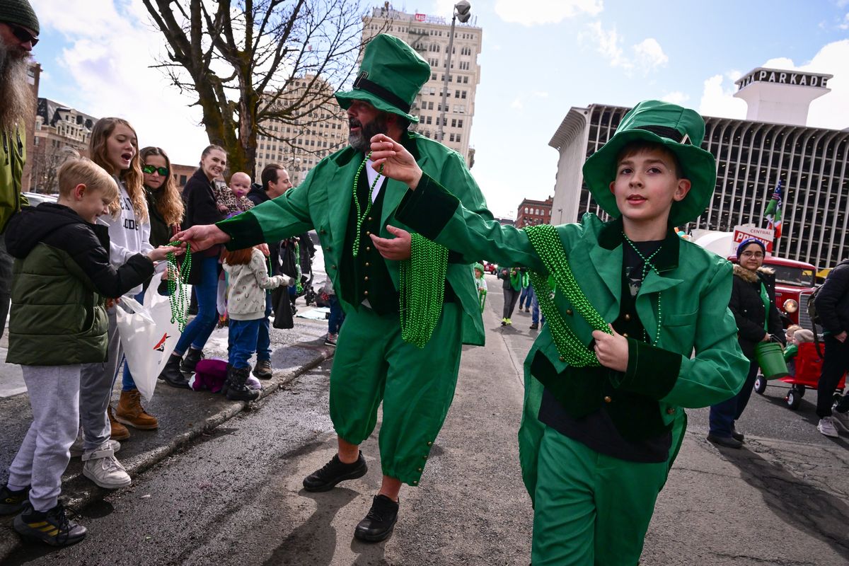 Jim Cameron Jr., left, and his son Jim Cameron III hand out beads to parade goers Saturday during the 43rd annual St. Patrick’s Day Parade in Spokane.  (Tyler Tjomsland/The Spokesman-Review)