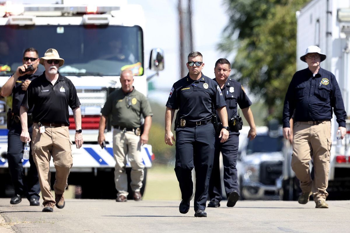 Lake Worth Police Chief J.T. Manoushagian, center, walks down Foster Drive near the location where a military training jet crashed on Sunday, Sept. 19, 2021, in Lake Worth, Texas. The jet crashed Sunday in a neighborhood near Fort Worth, Texas, injuring the two pilots and damaging three homes but not seriously hurting anyone on the ground, authorities said.  (Amanda McCoy)