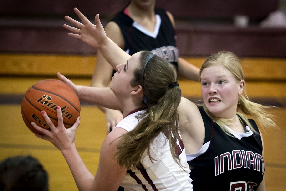 Mt. Spokane’s Isabella Allard drives to the basket as North Central’s Hannah George defends on Tuesday. (Colin Mulvany)