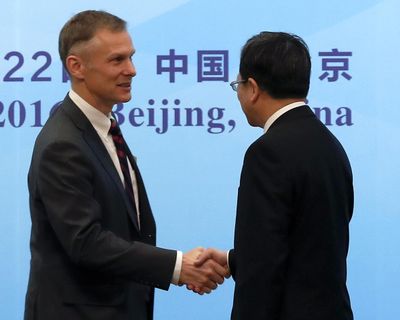 In this Nov. 21, 2016, file photo, Deputy Chief of Mission of U.S. Embassy Beijing David Rank, left, shakes hands with Director-General of the Department of Treaty and Law of the Foreign Ministry Xu Hong, right, at the opening ceremony of the 14th Plenary Session of the China-US Joint Liaison Group on Law Enforcement Cooperation at the Diaoyutai State Guest House in Beijing. Rank, the top-ranking diplomat at the U.S. Embassy in Beijing has abruptly resigned, telling colleagues he is leaving the foreign service over disagreements with Trump administration policy. (Andy Wong / Associated Press)