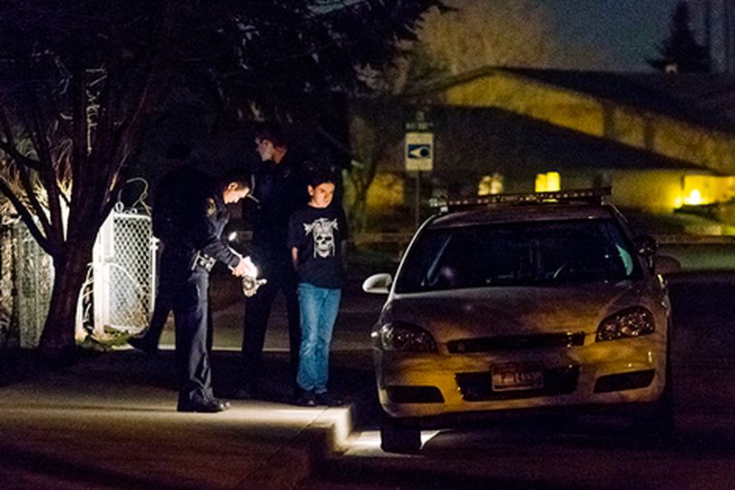 Coeur d'Alene Police prepare 14-year-old Eldon Samuel III for transport to the police department, where he was interviewed and booked Monday night. The teen was later charged as an adult with two counts of first-degree murder. (Shawn Gust/press)