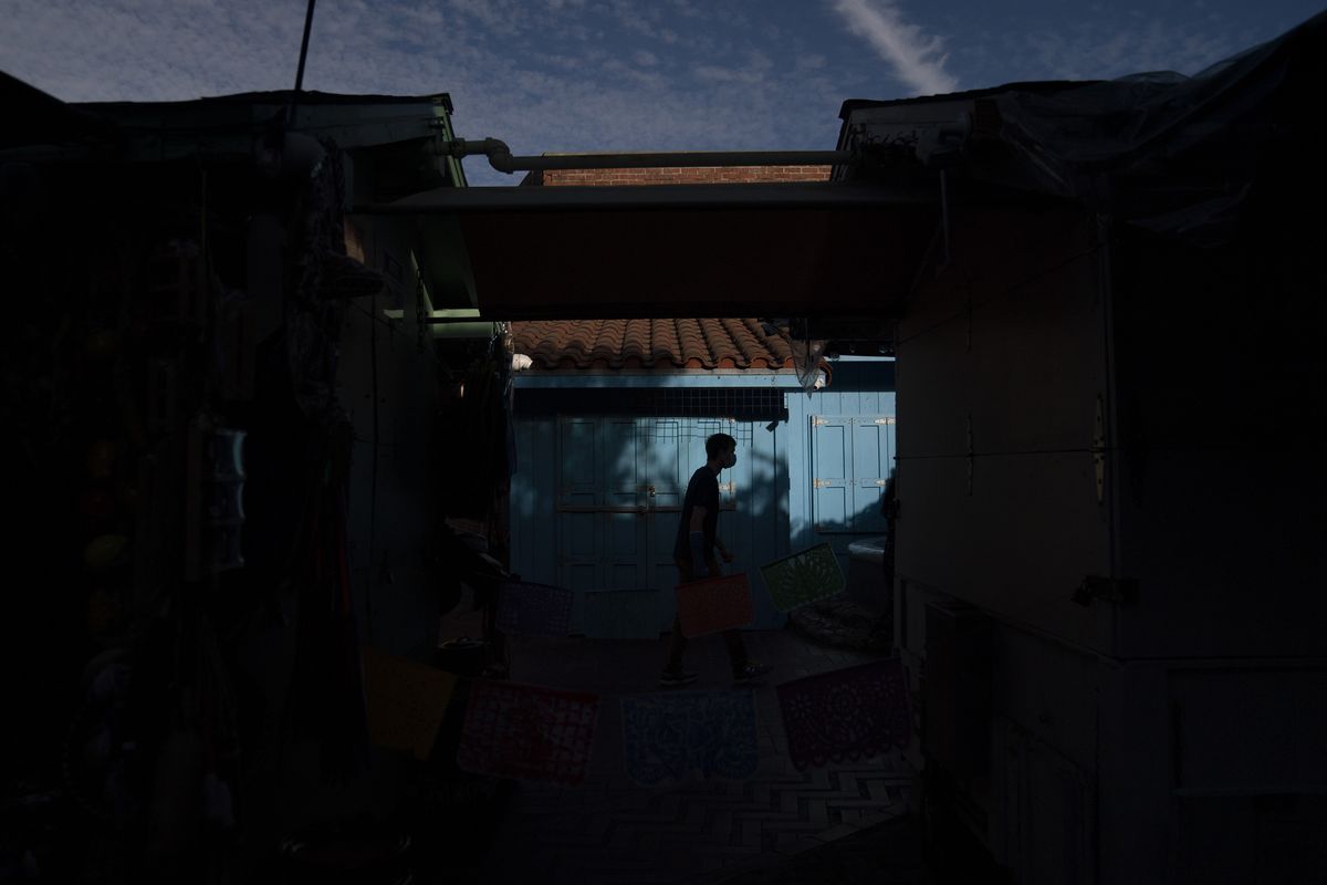 A man walks along Olvera Street Tuesday, June 8, 2021, in Los Angeles. Most businesses are no longer open daily and many have cut back to four or five days, said Valerie Hanley, treasurer of the Olvera Street Merchants Association Foundation and a shop owner. "We