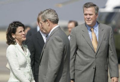 
President Bush, center, talks with Rep. Katherine Harris, R-Fla., as Florida Gov. Jeb Bush, right, looks on during the president's arrival at MacDill Air Force Base in Tampa on Tuesday. 
 (Associated Press / The Spokesman-Review)