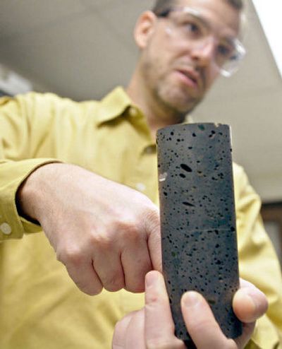 
Peter McGrail holds a basalt rock core sample and explains his project to capture carbon dioxide gas inside basalt formations at Pacific Northwest National Laboratory in Richland in November 2005. 
 (Associated Press / The Spokesman-Review)