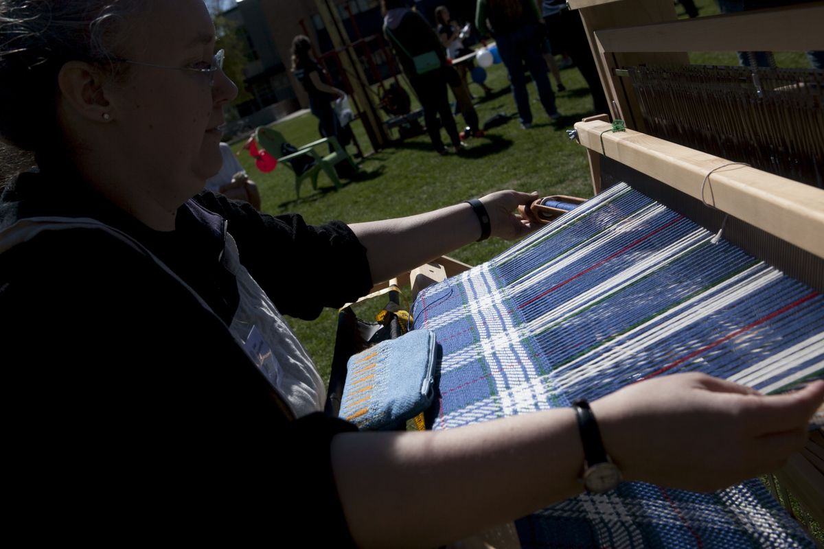 Jen Garrison Stuber weaves the first authentic Gonzaga tartan on Herak Field at Gonzaga University during a ceremony to announce it’s introduction on Friday. (Tyler Tjomsland)