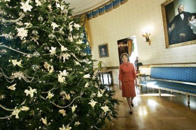 
First lady Laura Bush walks around the official White House Christmas tree in the Blue Room of the White House on Wednesday during a tour of the holiday decorations for the media. Among the decorations on the tree are fresh white lilies. 
 (Associated Press / The Spokesman-Review)