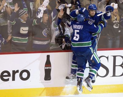 Canucks’ Christian Ehrhoff, left, and Alex Burrows celebrate Burrows’ goal in the first period Tuesday night. (Associated Press)