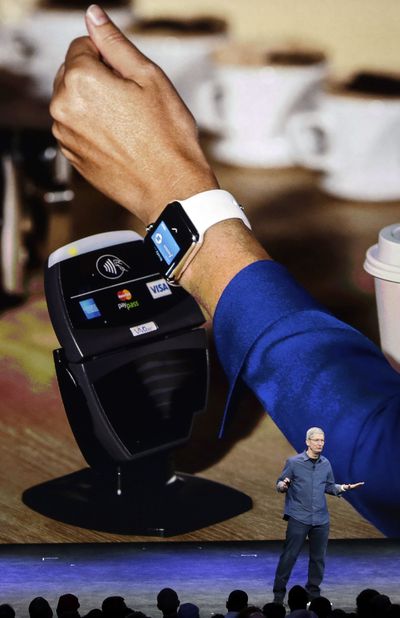 Apple CEO Tim Cook explains how the Apple Watch works in conjunction with Apple Pay during an announcement Sept. 9 of new products in Cupertino, Calif. (Associated Press)