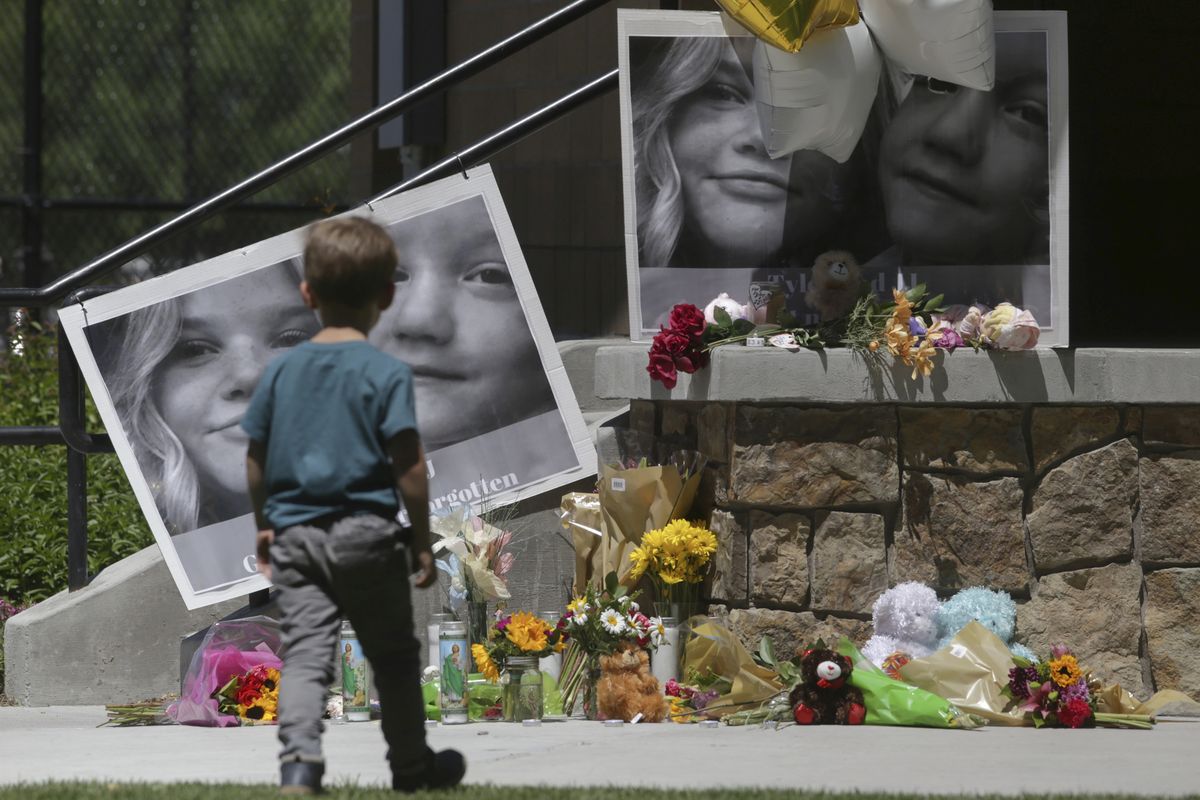 FILE - In this June 11, 2020, file photo, a boy looks at a memorial for Tylee Ryan, 17, and Joshua "JJ" Vallow, 7, at Porter Park in Rexburg, Idaho. Prosecutors say the mother of the two children who were found dead in rural Idaho months after they vanished had conspired with her new husband to hide or destroy the kids’ bodies. The new felony charges against Lori Vallow Daybell came late Monday, June 29.  (John Roark)
