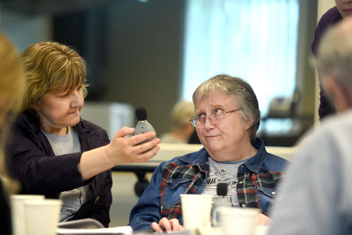 Speech therapist Doreen Nicholas, left, holds a sound meter and gets a grimace from client Pam Spino each time she reminds Spino to speak louder during a speech therapy group for Parkinson