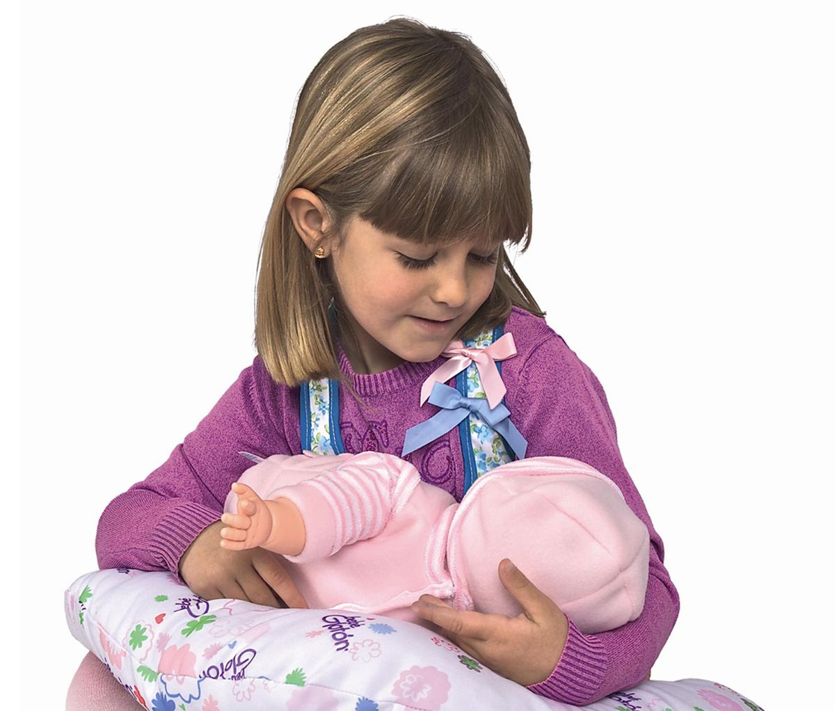 This product image released by Berjuan Toys shows  a girl playing with The Breast Milk Baby doll. The breastfeeding doll, whose suckling sounds are prompted by sensors sewn into a halter top, has caught some flak after hitting the U.S. market. (Berjuan Toys)