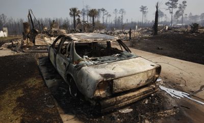 A car and houses lay destroyed Thursday  in the Barefoot Resort community in North Myrtle Beach, S.C., after the state’s biggest wildfire in more than three decades swept through the area.  (Associated Press / The Spokesman-Review)