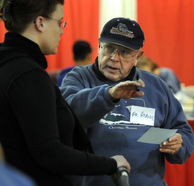 The Rev. Frank Bach directs a first-time Christmas Bureau recipient  through the line Friday.