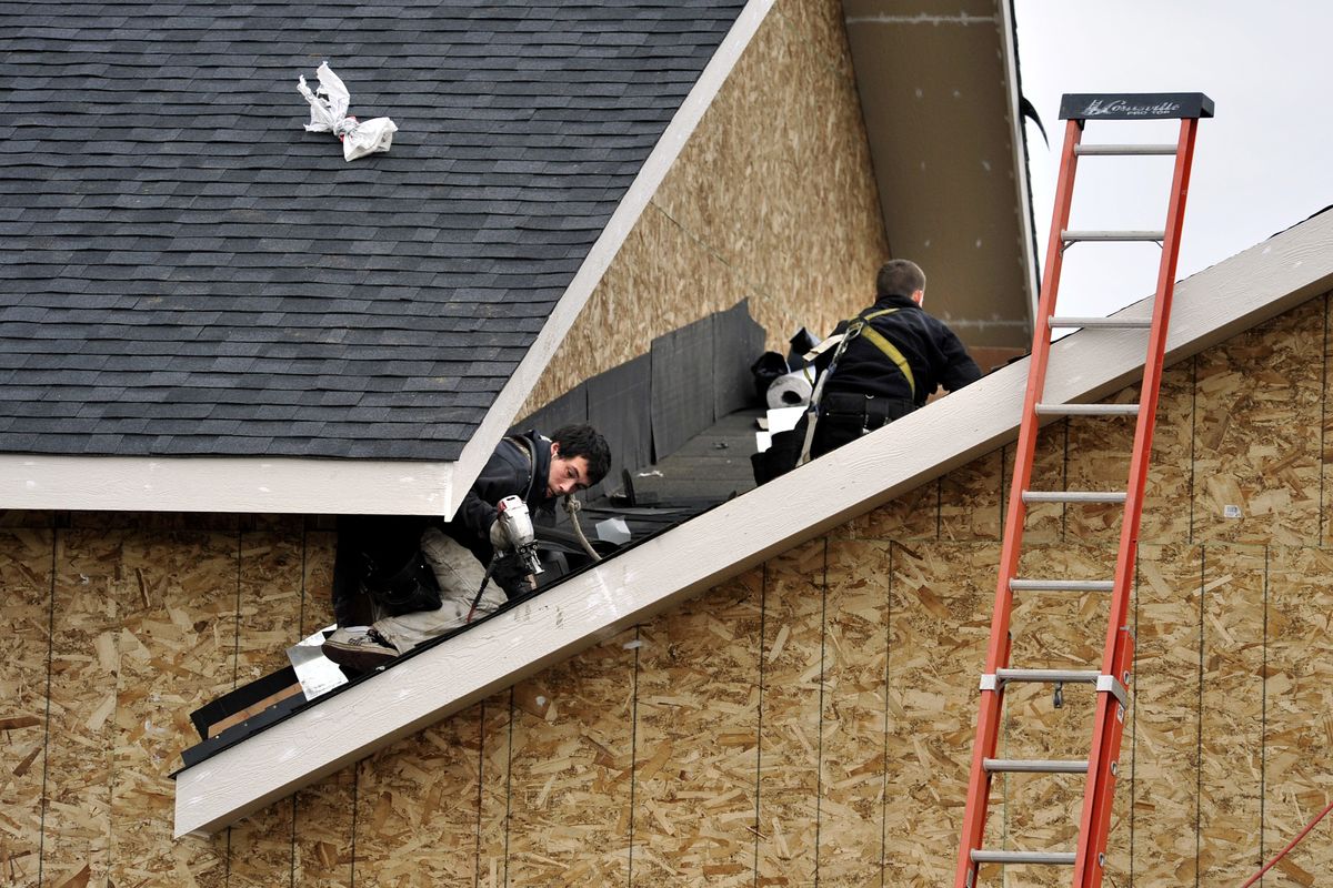 Jessie Steffen, left, and Mitchell Clark, of Premier Roofing, nail shingles onto the new Christ Church of Mt. Spokane at 5601 Peone Road in Mead.  (Dan Pelle)