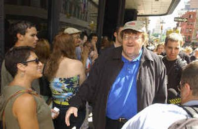 
Director Michael Moore greets moviegoers seeing his film 