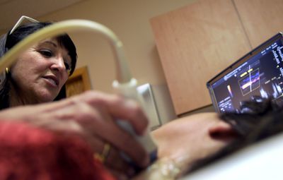 Terri  Porcarelli, a registered diagnostic medical sonographer, works with a patient on  April 22 at Inside View Health Screening.  (Kathy Plonka / The Spokesman-Review)